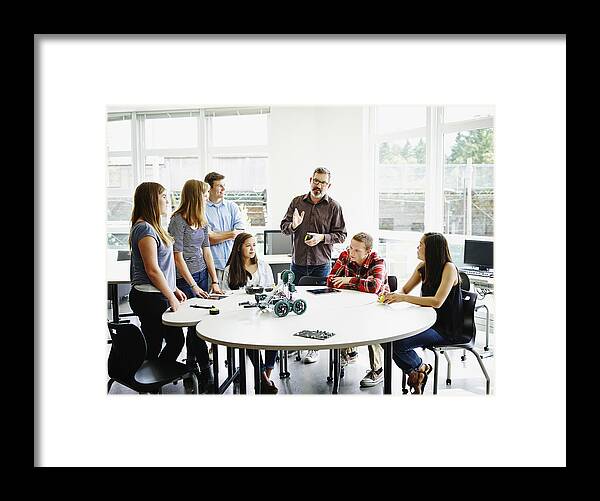 Education Framed Print featuring the photograph Male teacher in discussion during robotics class by Thomas Barwick