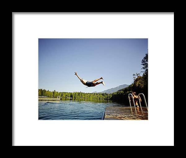 Tranquility Framed Print featuring the photograph Man Diving Off Dock Into Mountain Lake by Thomas Barwick
