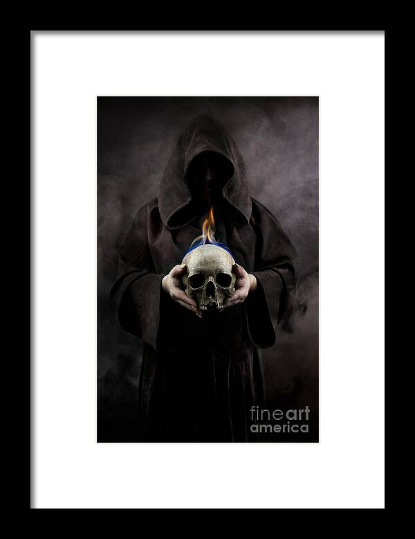 Hood Framed Print featuring the photograph Man in the hooded cloak holding burning human skull in his hand by Jaroslaw Blaminsky