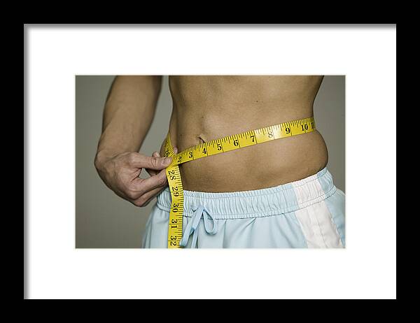 Inch Framed Print featuring the photograph Man measuring waist , mid section by Photodisc