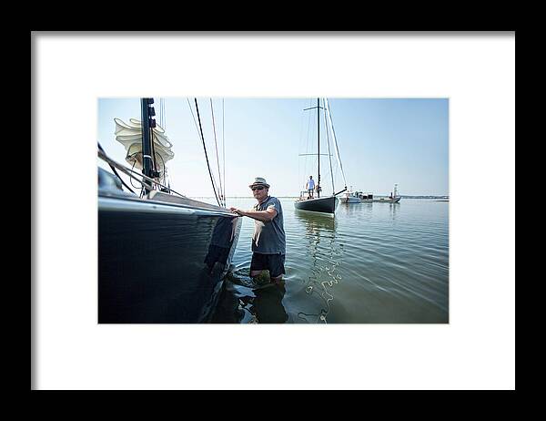 Walking Framed Print featuring the photograph Man Walking In Sea Near Sailboat, Ile by Christophe Launay