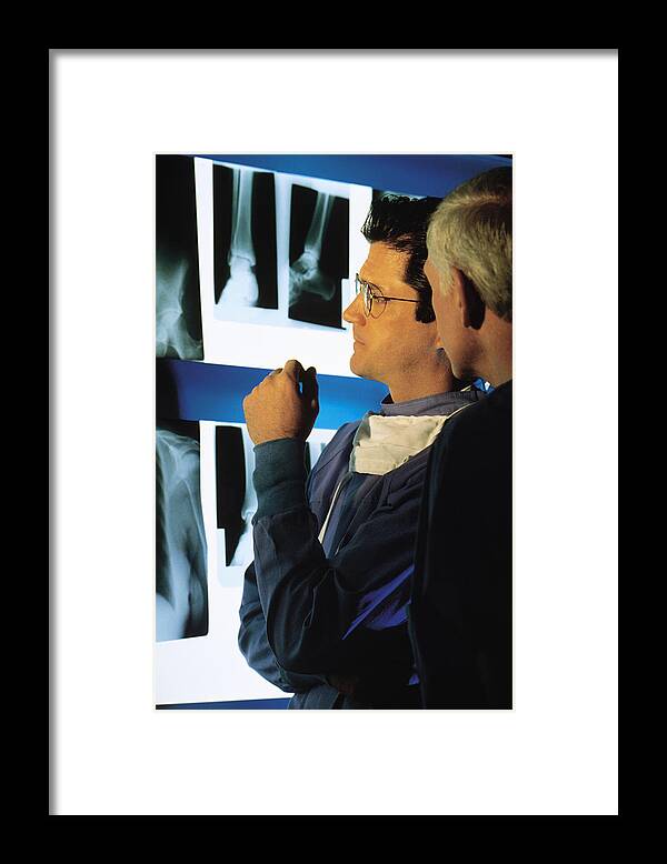 Mature Adult Framed Print featuring the photograph Medical professionals examining x-rays by Comstock