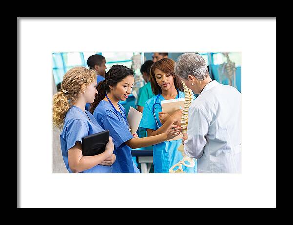 Education Framed Print featuring the photograph Medical school professor using model to teach nursing students by Steve Debenport