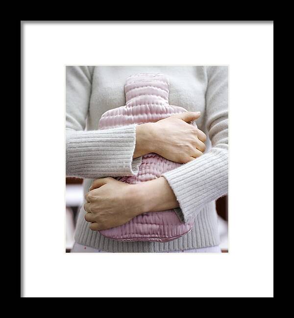 Sweater Framed Print featuring the photograph Mid Section Shot of a Woman Holding a Pink Water Bottle Against Her Stomach by Digital Vision.