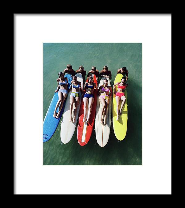 Fashion Framed Print featuring the photograph Models Wearing Bikinis Lying On Surfboards by William Connors
