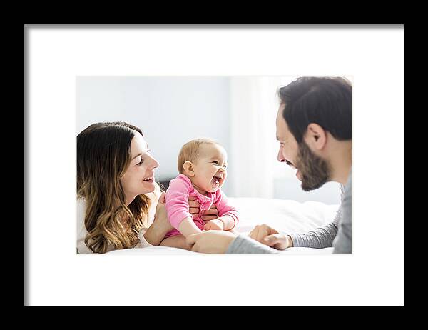 Child Framed Print featuring the photograph Mother father and baby child on a white bed by LSOphoto