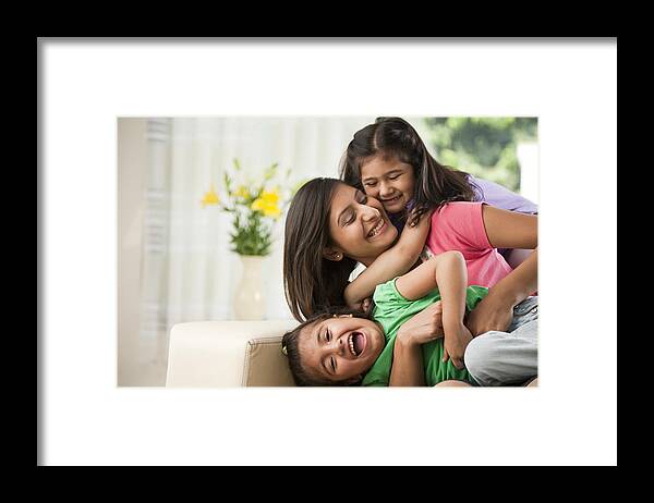 New Delhi Framed Print featuring the photograph Mother with daughters (6-7) sitting on sofa by ImagesBazaar