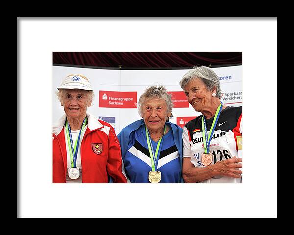 Three People Framed Print featuring the photograph Older Female Athletes On Medals Rostrum by Alex Rotas