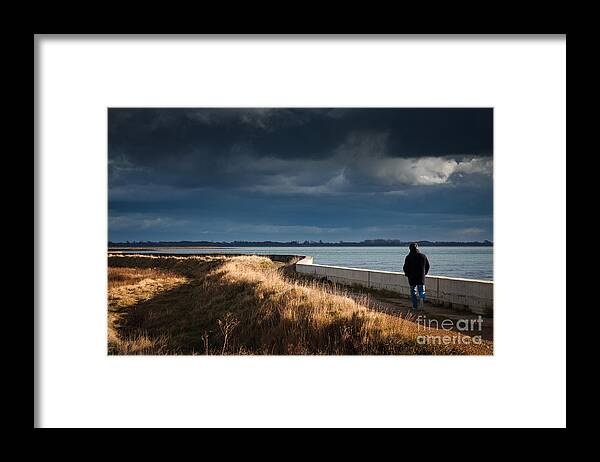 England Framed Print featuring the photograph One Man Walking Alone By Sea Wall In Sunshine On Dramatic Stormy by Peter Noyce