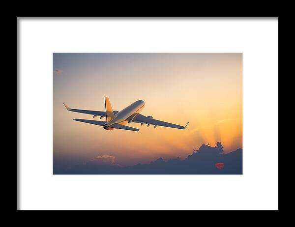 Taking Off Framed Print featuring the photograph Passenger airplane flying above clouds during sunset by Spooh