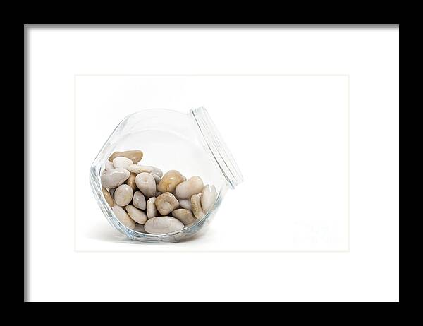 Pebble Framed Print featuring the photograph Pebbles in a Glass Jar against White Background by Natalie Kinnear