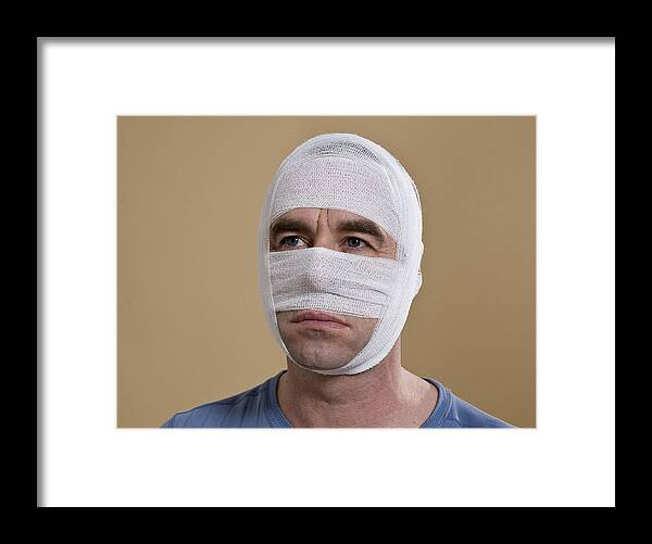 Material Framed Print featuring the photograph Portrait of a man with a bandaged face by Uwe Umstatter