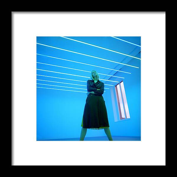 Tranquility Framed Print featuring the photograph Portrait of beautiful young woman in neon light by Andriy Onufriyenko