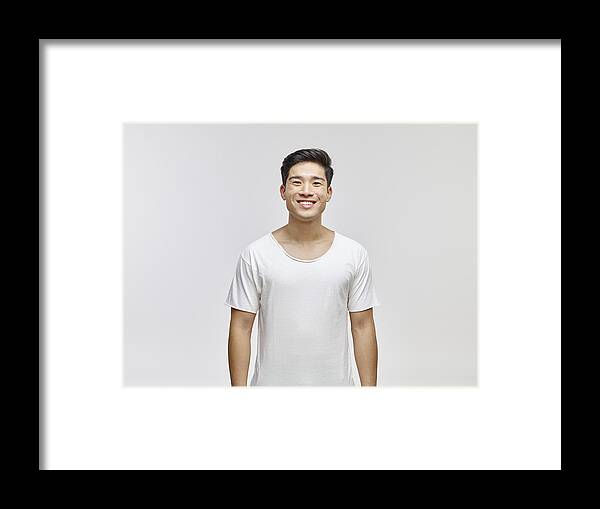 Young Men Framed Print featuring the photograph Portrait of smiling young man wearing white t-shirt by Westend61