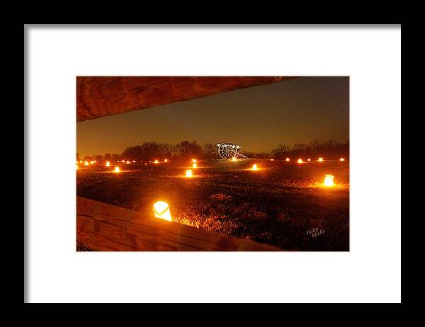 Looking Through A Split-rail Fence At A Solitary Cannon That Sits In The Middle Of This Field And Is Surrounded By Hundreds Of Luminaries. Each Year 23 Framed Print featuring the photograph Solitary Cannon 12 by Judi Quelland
