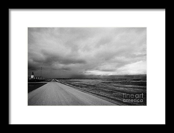 Storm Framed Print featuring the photograph storm snow clouds forming over country road on the prairies assiniboia Saskatchewan Canada by Joe Fox