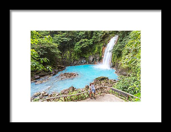Young Men Framed Print featuring the photograph Tourist couple looking at Rio Celeste waterfall by Matteo Colombo