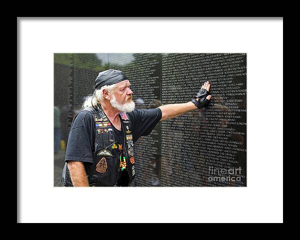 Memorial Framed Print featuring the photograph Vietnam veteran pays respect to fallen soldiers at the Vietnam War Memorial by B Christopher