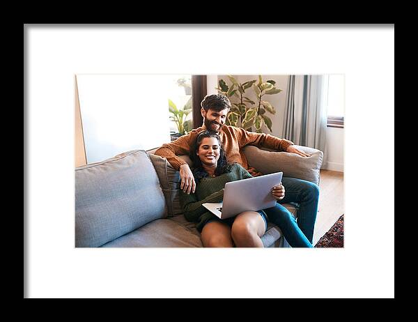 Young Men Framed Print featuring the photograph Wireless entertainment for a lazy day at home by PeopleImages