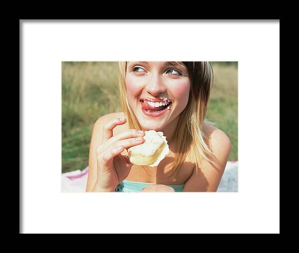 People Framed Print featuring the photograph Woman eating a cake by Image Source