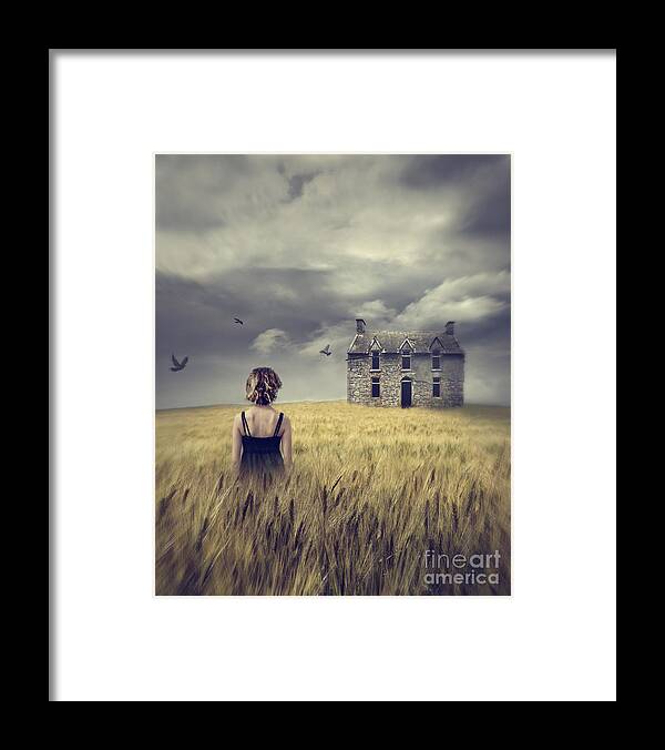 Alone Framed Print featuring the photograph Woman walking in wheat field with abandoned house in background by Sandra Cunningham