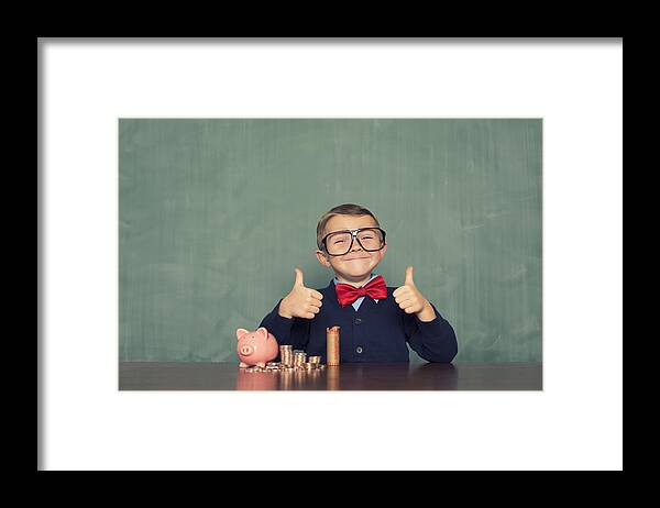 4-5 Years Framed Print featuring the photograph Young Boy Nerd Saves Money in His Piggy Bank by RichVintage