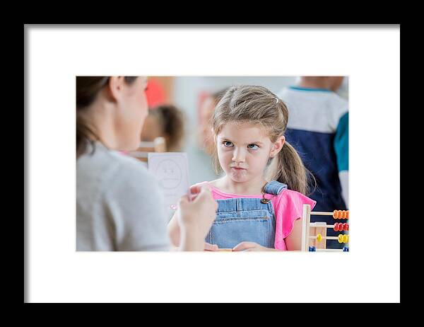 Education Framed Print featuring the photograph Young schoolgirl mimics face on emotion flash card by Steve Debenport