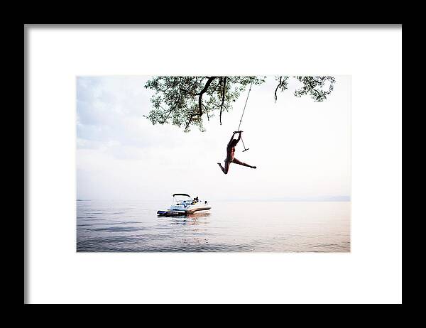 Adventure Framed Print featuring the photograph Young Woman On Rope Swing With Boat by Monica Donovan