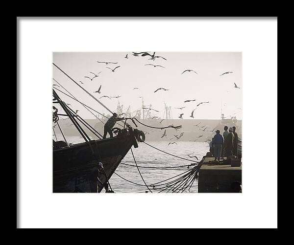 Man Throwing Rope To People On Dockside Framed Print by Axiom