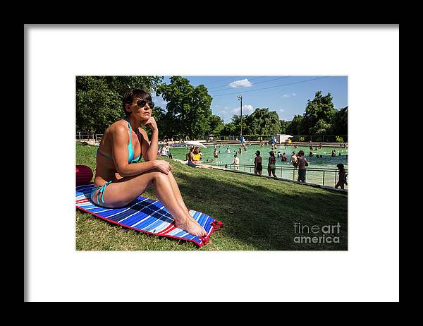 Deep Eddy Pool Framed Print featuring the photograph A fit Austin woman sunbathes in a bikini at Deep Eddy Pool, surrounded by grassy slopes which are the best in Austin for sunbathing by Dan Herron