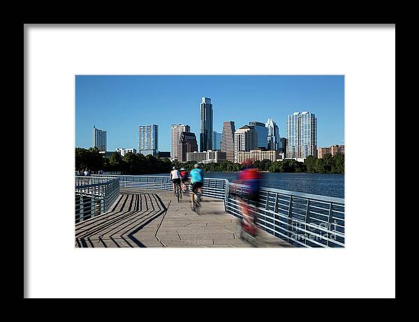 The Boardwalk Framed Print featuring the photograph A group of cyclists ride down the Boardwalk Trail which offers stunning views of the Austin skyline by Dan Herron