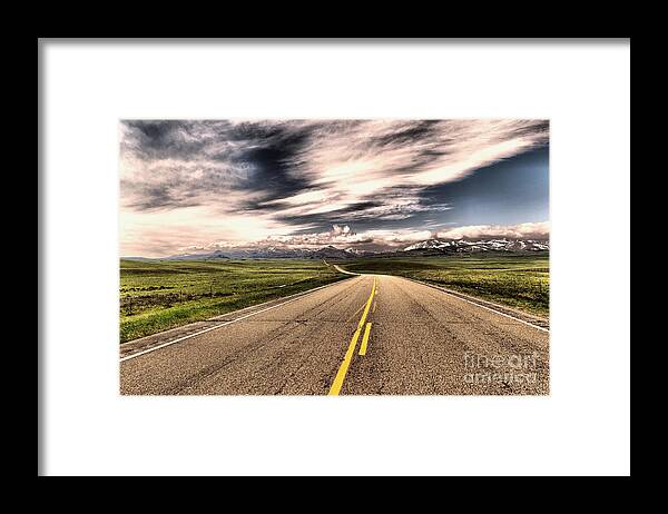 Road Framed Print featuring the photograph A long road to the mountains by Jeff Swan