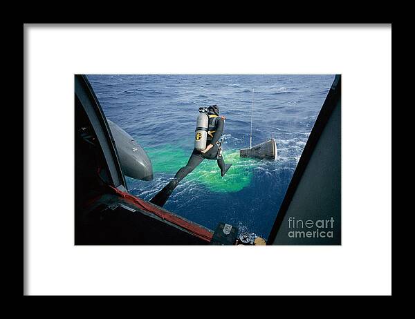 Gemini12 Framed Print featuring the photograph A Navy frogman leaps from recovery helicopter into water to assist the Gemini 12 recovery operations by Vintage Collectables
