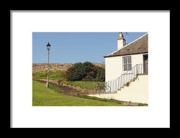 House On The Slope Framed Print featuring the photograph House on the slope with a bike and a lamppost. by Elena Perelman