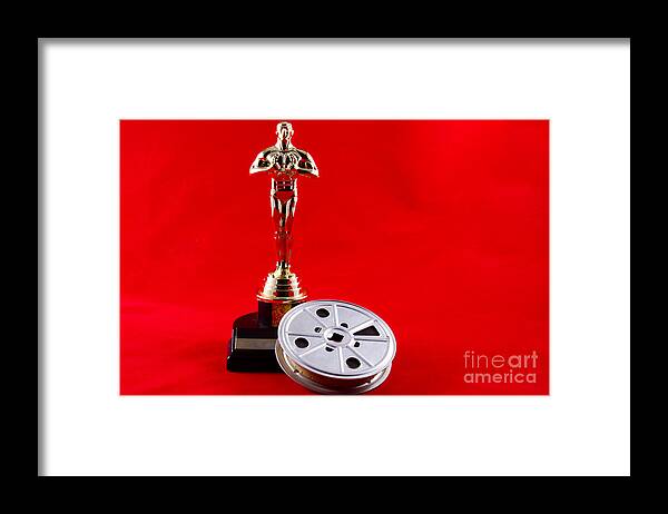 Academy Framed Print featuring the photograph Oscar Statuette with Movie Reel by Karen Foley