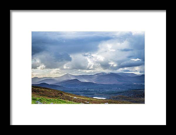Blackvalley Framed Print featuring the photograph Sun rays piercing through the clouds touching the Irish landscap by Semmick Photo
