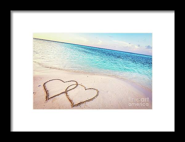 Beach Framed Print featuring the photograph Two hearts drawn on sand of a tropical beach at sunset. by Michal Bednarek