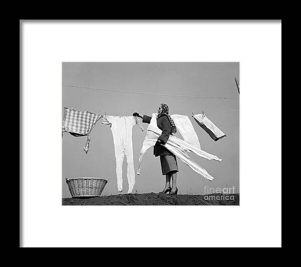 1940s Framed Print featuring the photograph Woman Removing Frozen Clothes by Debrocke/ClassicStock