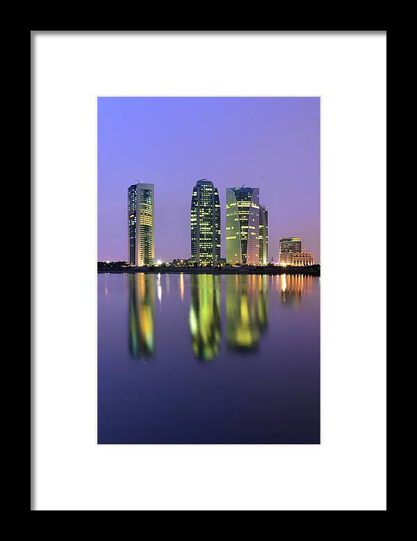 Tranquility Framed Print featuring the photograph 4 Skyscrapers Glow At Night Over The by Photography By Azrudin