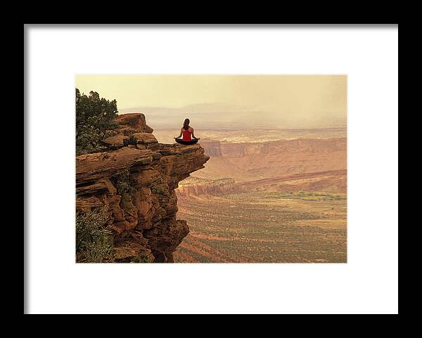 Tranquility Framed Print featuring the photograph A Woman In The Lotus Yoga Position On A by Per Breiehagen