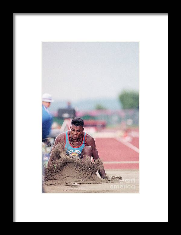 People Framed Print featuring the photograph Carl Lewis Lands In Sand After Long Jump by Bettmann