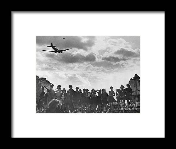 Child Framed Print featuring the photograph Children Watch Food Airlift Plane Arrive by Bettmann