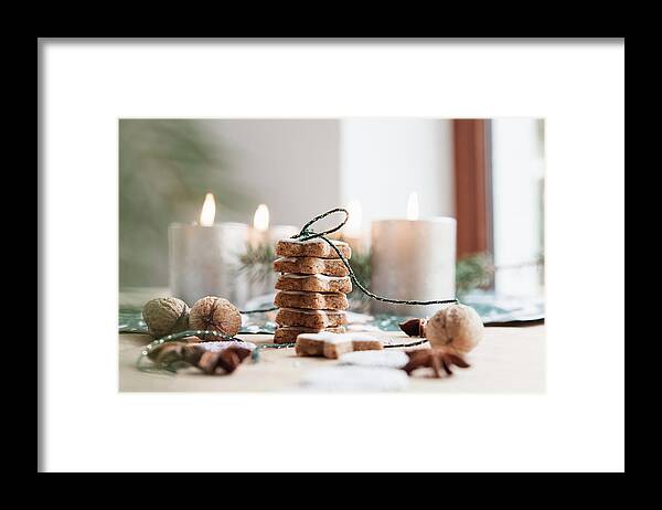 Ip_13260979 Framed Print featuring the photograph Cinnamon Stars With Burning Candles In The Background by Jelena Filipinski