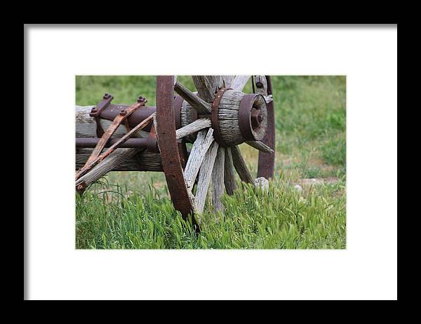 Wagon Wheel Framed Print featuring the photograph Closeup Vintage Wooden Wagon Wheel in Grass by Colleen Cornelius