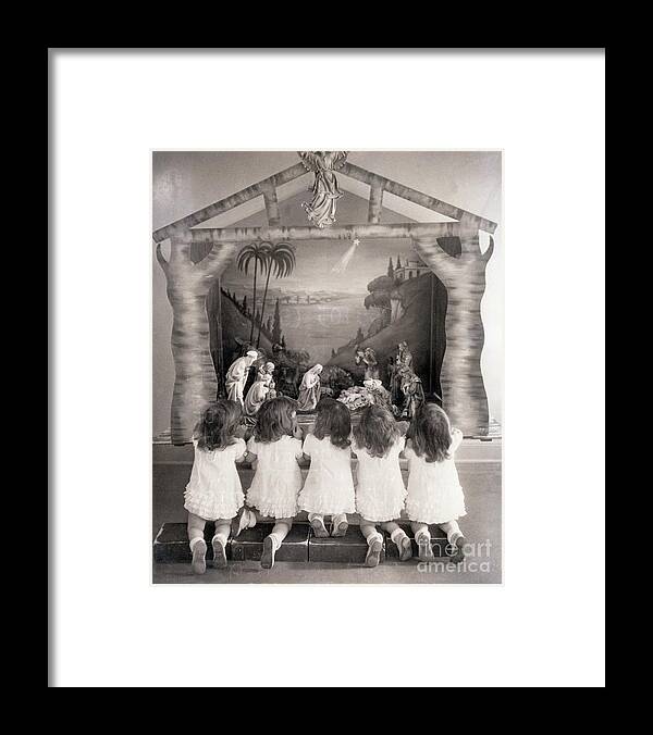 Child Framed Print featuring the photograph Dionne Quintuplets Kneel At Creche by Bettmann