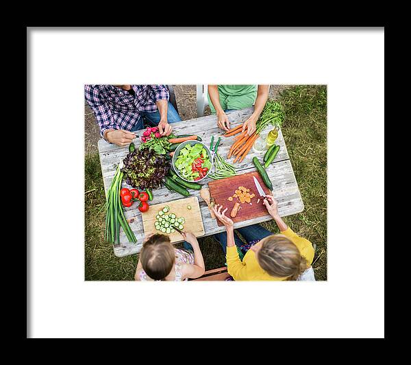 Orange Color Framed Print featuring the photograph Family Preparing Salad In Garden by Hinterhaus Productions
