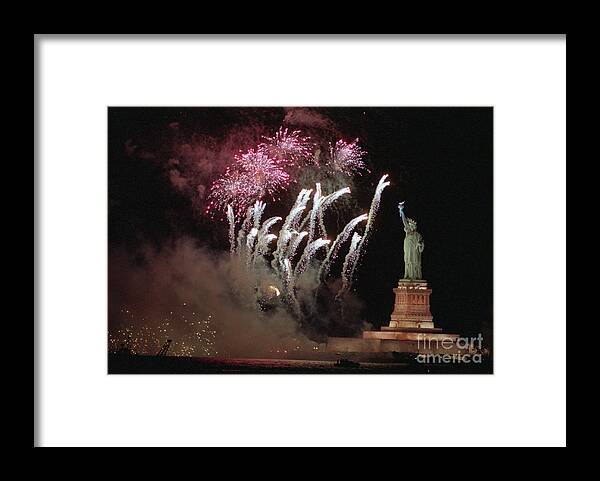 Following Framed Print featuring the photograph Fireworks Exploding Near Statue by Bettmann