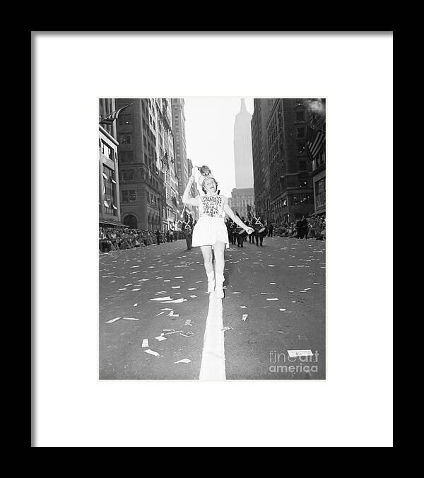 Marching Framed Print featuring the photograph Girl Twirls Baton Leading Marching Band by Bettmann