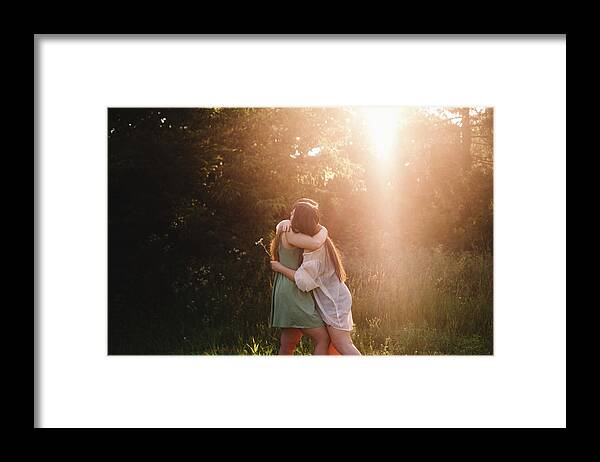 Lesbian Couple Framed Print featuring the photograph Lesbian Couple Embracing In Forest During Summer by Cavan Images