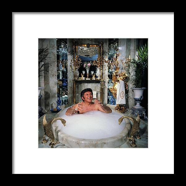 Mature Adult Framed Print featuring the photograph Liberace Taking A Bubble Bath by Bettmann